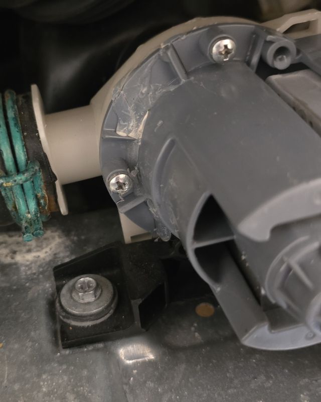 Washer drain pump with a corroded hose clamp on the drain hose